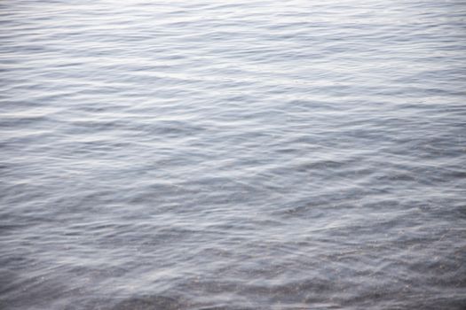 Calm water surface showcasing gentle ripples and natural reflection.