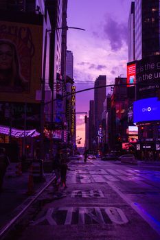 Colorful cityscape during twilight in an urban setting with vibrant lights and skyscrapers.