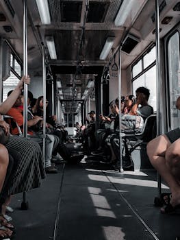A diverse group of people seated in a moving subway train, illustrating city life.