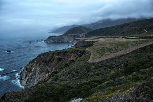 Free Gorgeous aerial view of coastal cliffs and ocean under a cloudy sky, showcasing dramatic natural beauty. Stock Photo