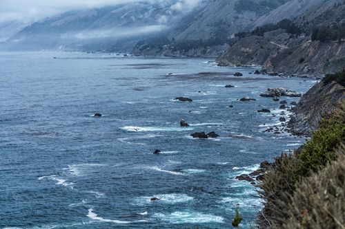 Free Scenic view of rocky coastline and ocean waves under cloudy skies. Stock Photo