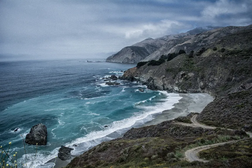 Explore the rugged beauty of a dramatic coastline with rocky cliffs and churning waves.