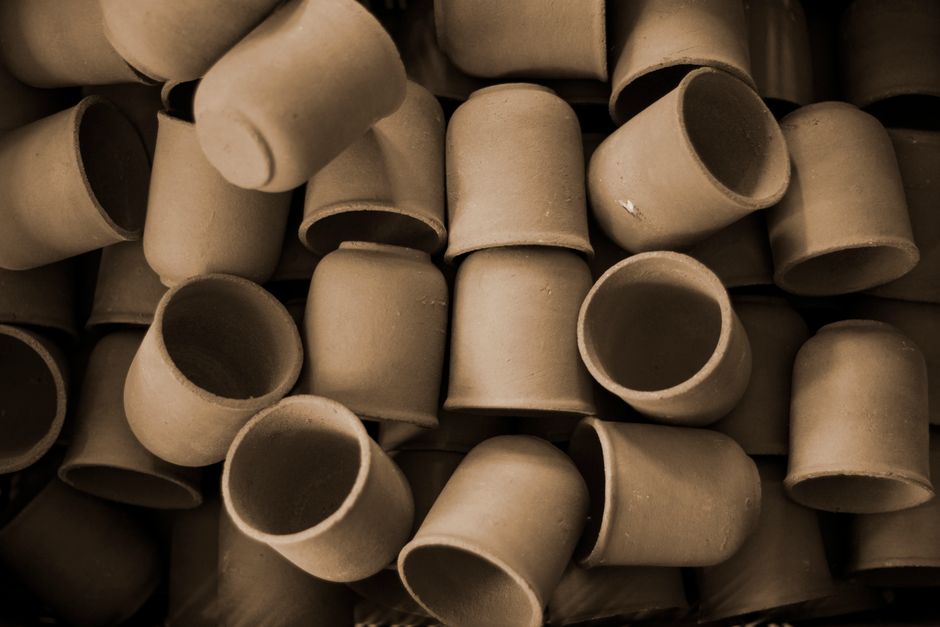Close-up view of handmade clay pots stacked together, showcasing texture and natural tones.