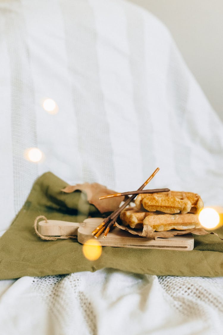 Waffles With Chocolate Sticks On A Wooden Chopping Board
