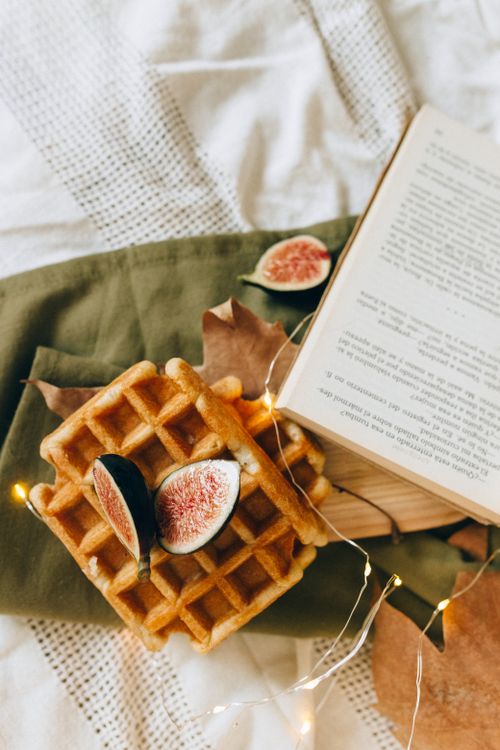 Free Warm waffles topped with fresh figs, set on a textured cloth alongside an open book in a cozy autumn setting. Stock Photo