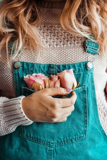 Delicate roses in a denim pocket captured with a soft focus on texture and color.