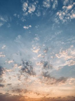 A tranquil view of a colorful sky filled with scattered clouds during sunset.