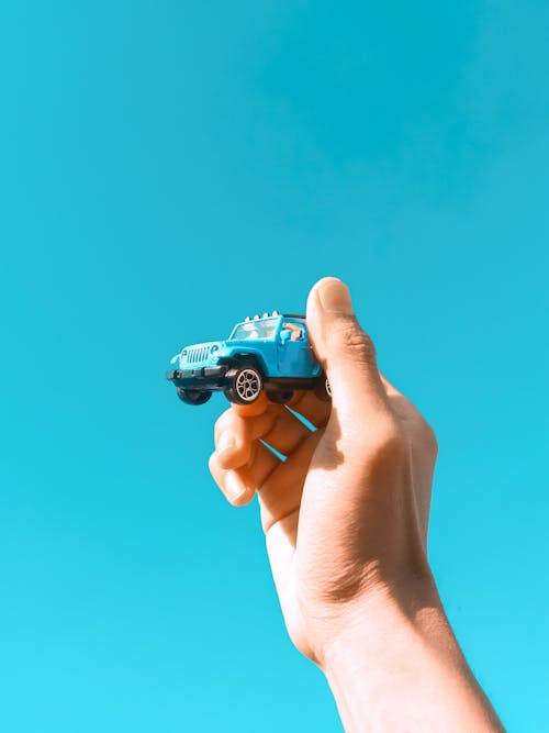 Person Holding Blue and Black Toy Car
