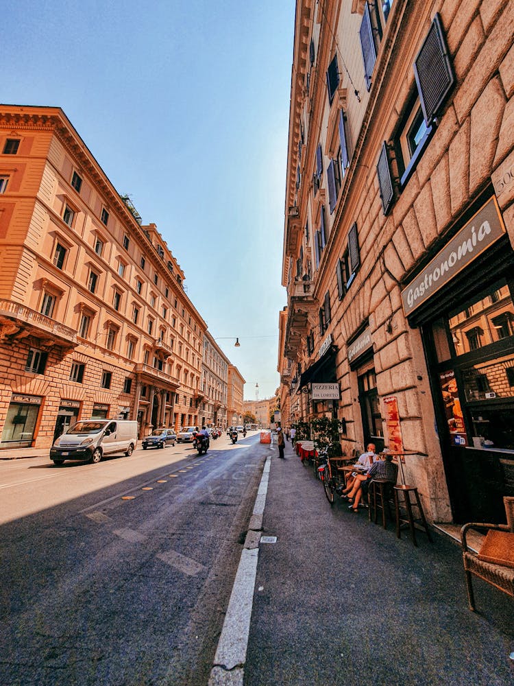 Road Going Between Old Residential Buildings At Street Cafe