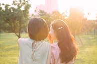 Woman Whispering on Another Woman's Ear