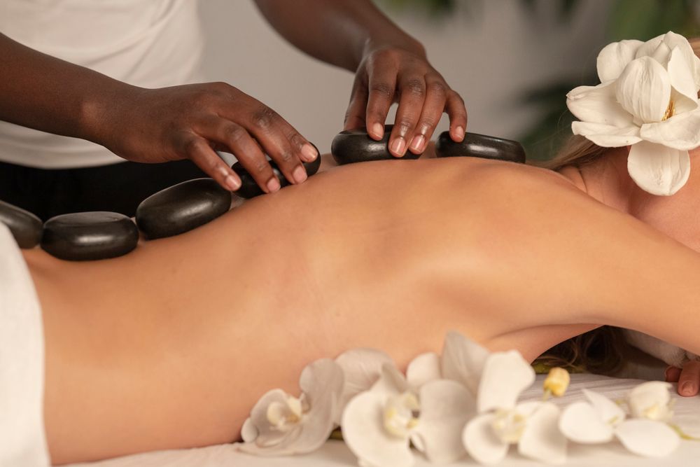 Hot stone massage treatment with massage stones and professional therapist