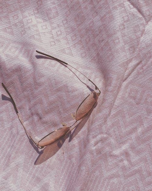 Sunglasses on Pink Textile