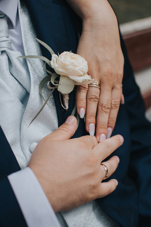 Unrecognizable bride and groom showing golden wedding rings on fingers during wedding ceremony