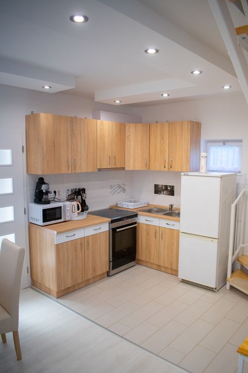 Free Comfortable furniture inside modern kitchen with counter and cupboards with appliances under suspended ceiling Stock Photo
