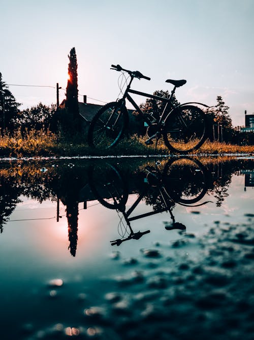 Bicycle Reflecting in Puddle at Sunset