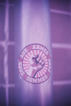 Close-up of a protest sticker on a wall featuring a raised fist symbolizing resistance.