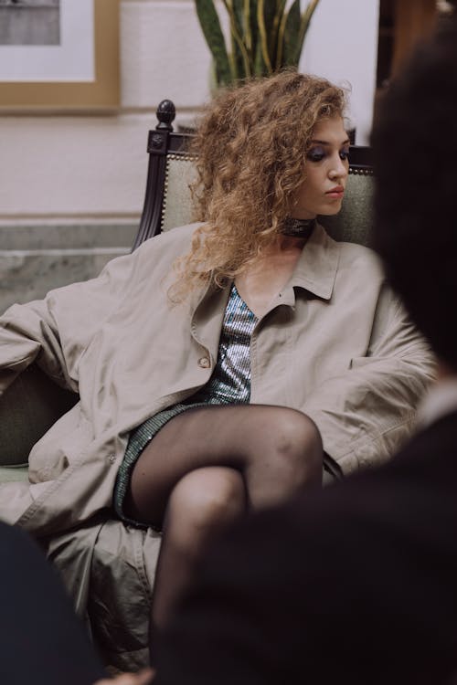 Woman Wearing Trench Coat Sitting on a Chair 