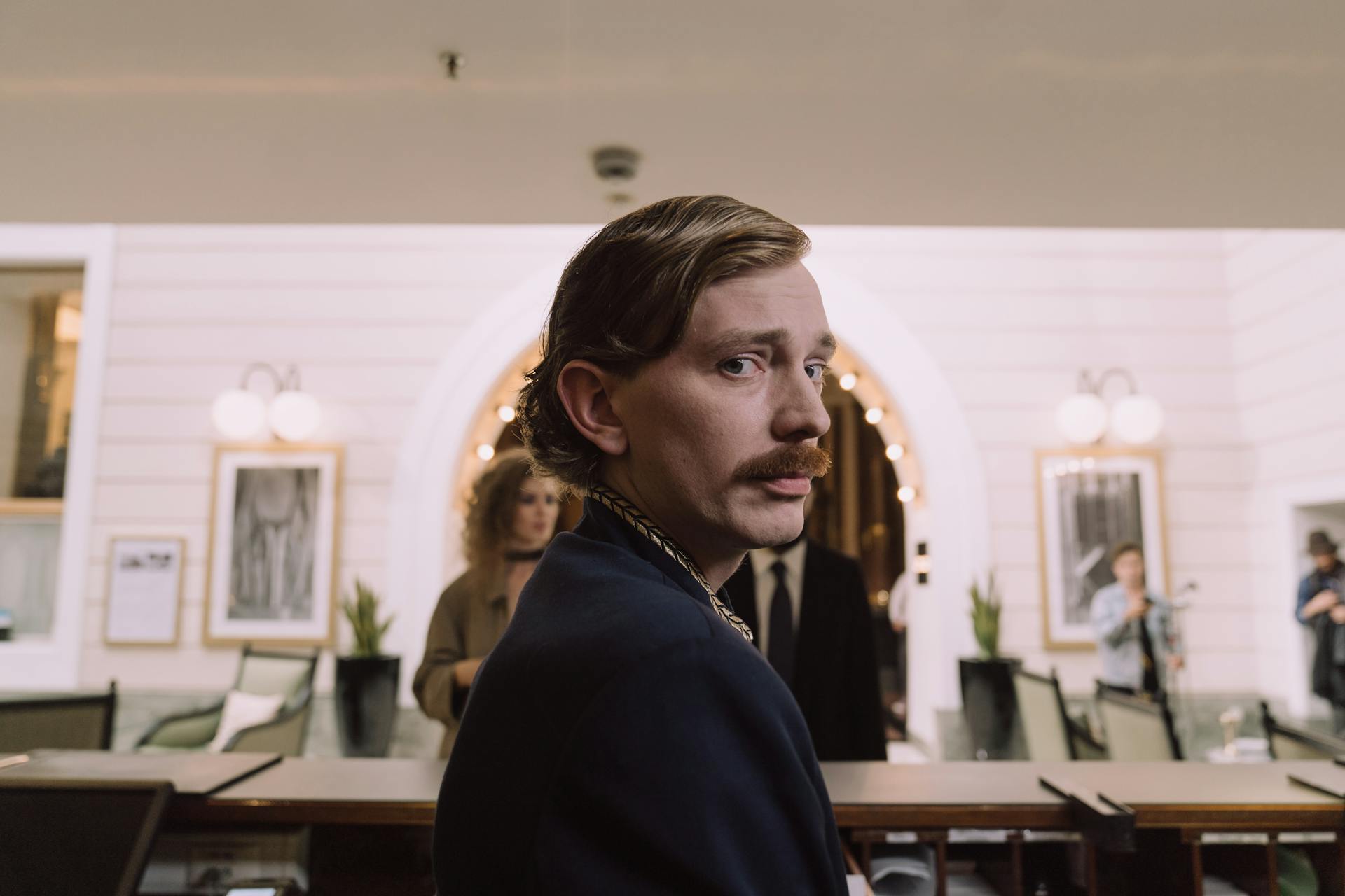 Hotel concierge at the front desk with a classic ambiance in the background.