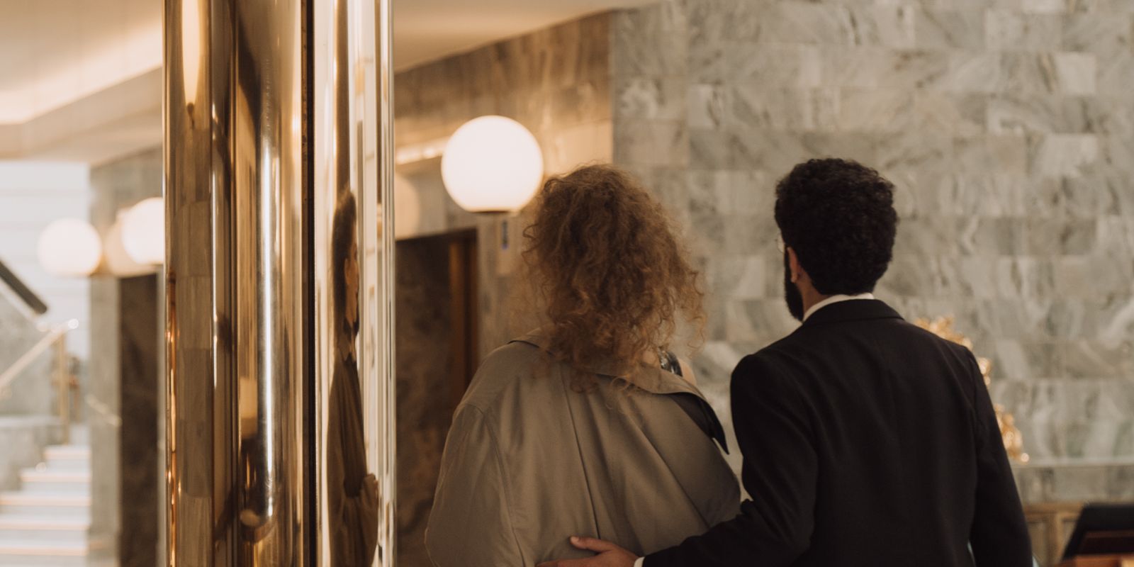 A couple walking in a luxurious hotel lobby, showcasing elegance and sophistication - historic hotels and inns