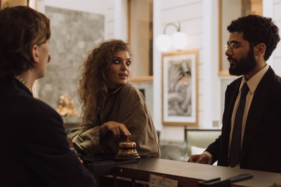 Concierge in a suit helping guests at a hotel desk