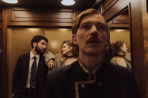 A Bellboy and a Couple Standing Inside an Elevator