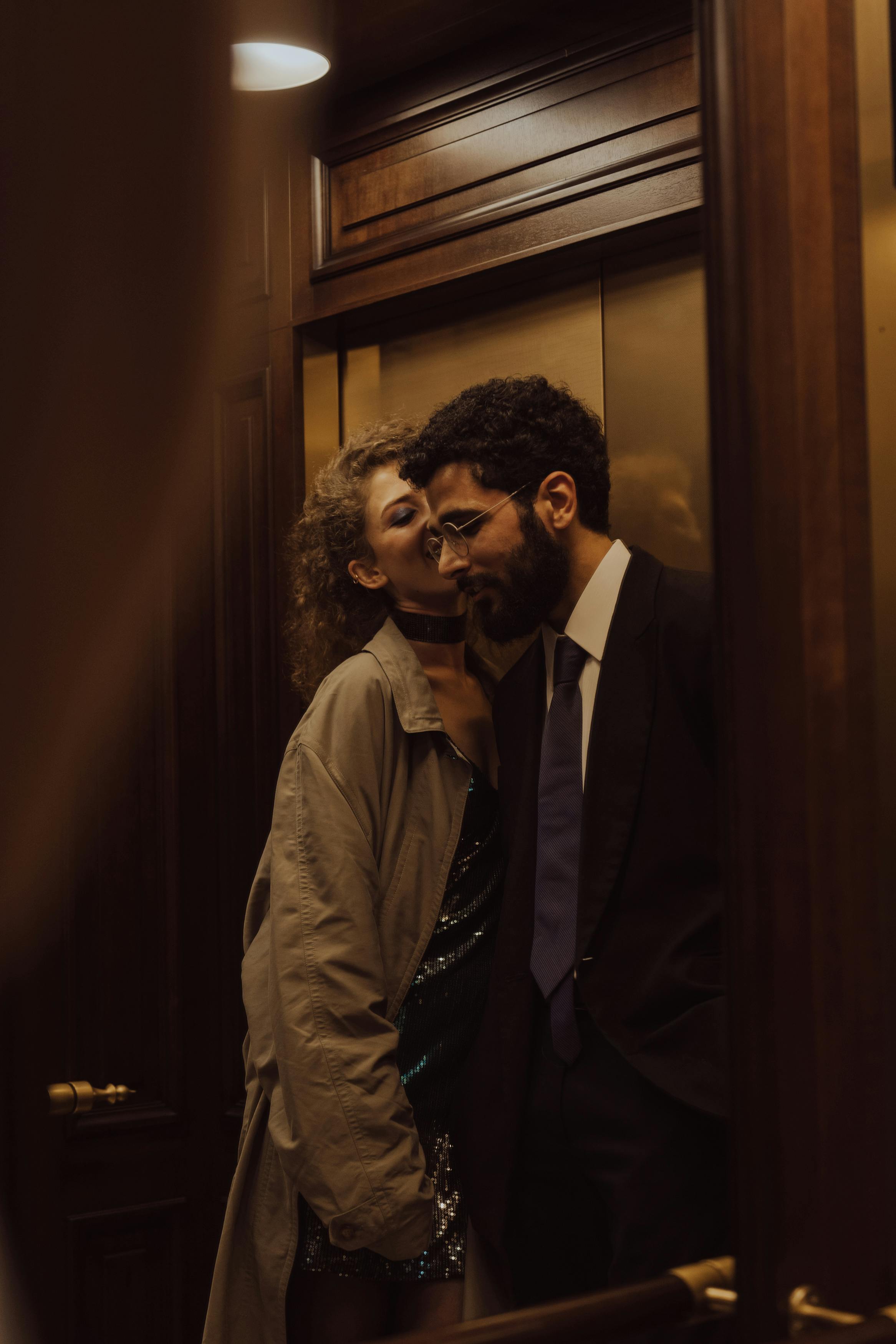 man and a woman standing inside an elevator