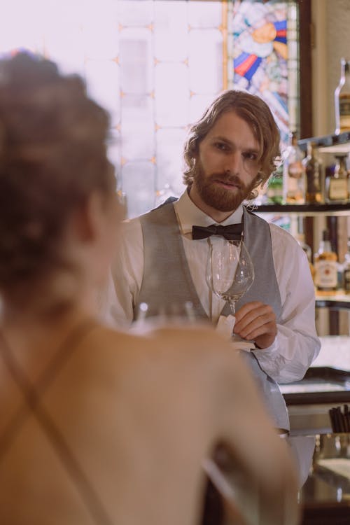 Bartender Looking at a Woman while Holding a Wine Glass