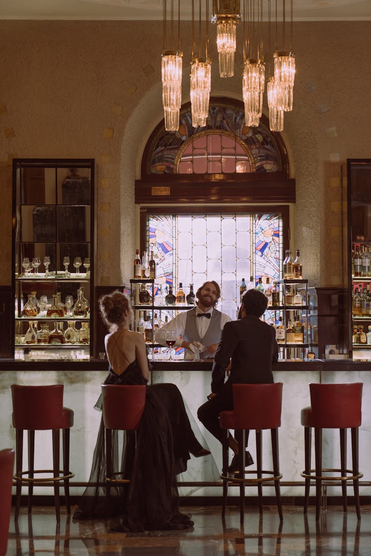 Bartender Serving A Couple At The Bar