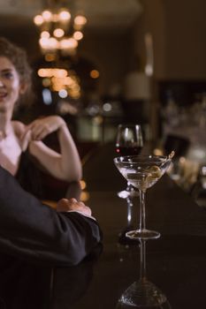 一对优雅的夫妇在豪华酒吧享用鸡尾酒和葡萄酒，非常适合浪漫的夜晚