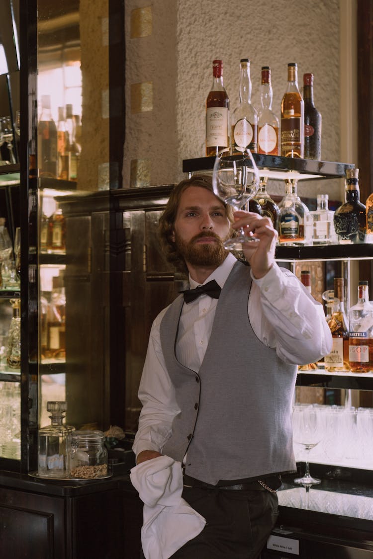 Bartender Holding And Looking At A Wine Glass