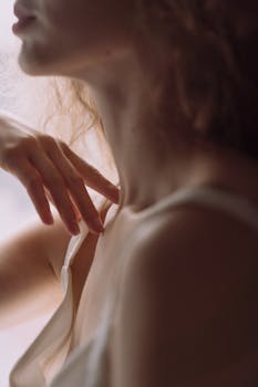 在平静的氛围中，一幅柔焦的女性肖像突出了她精致的脖子和手