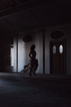 光线昏暗的房间里，一位身着飘逸婚纱的女子剪影在奔跑，营造出神秘而戏剧性的氛围