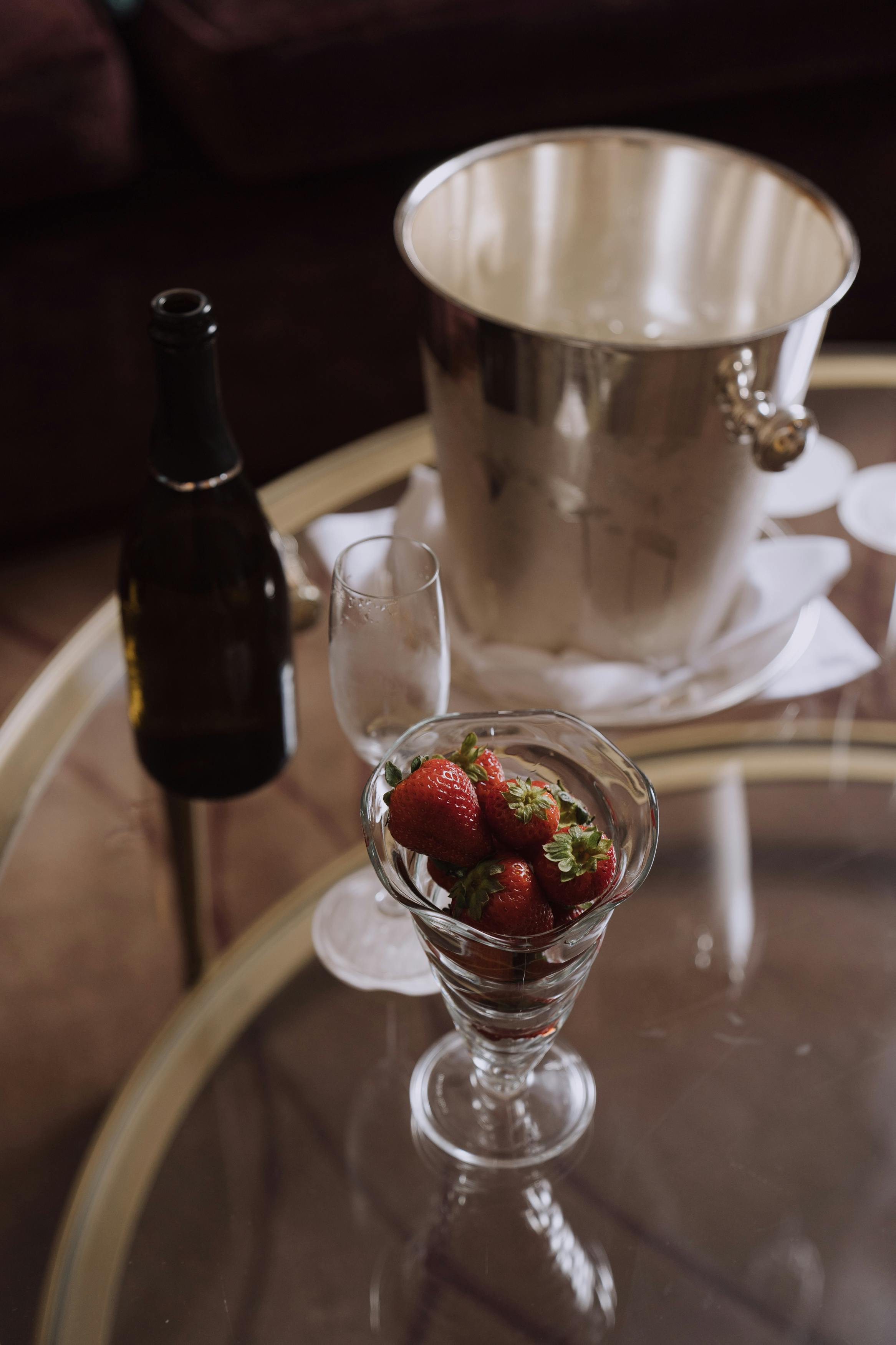 close up view of a wine glass and strawberries