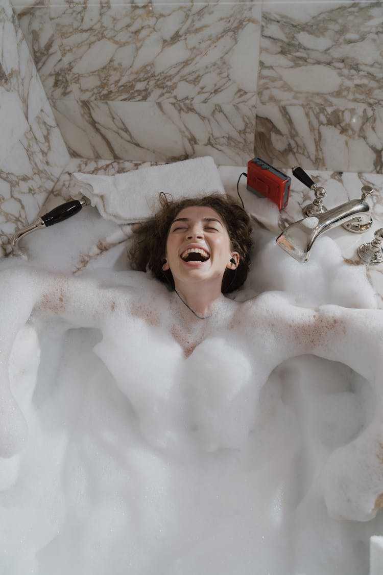 Smiling Woman In A Bathtub Listening To Music