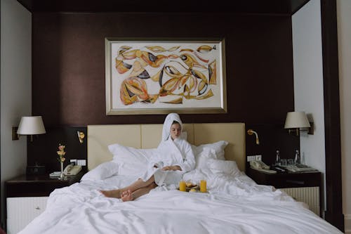 Free Woman in Bathrobe Sitting on Bed Stock Photo