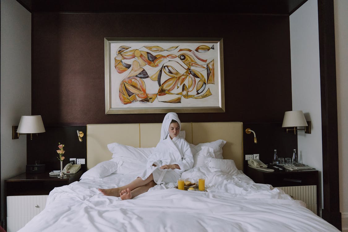 Woman in Bathrobe Sitting on Bed