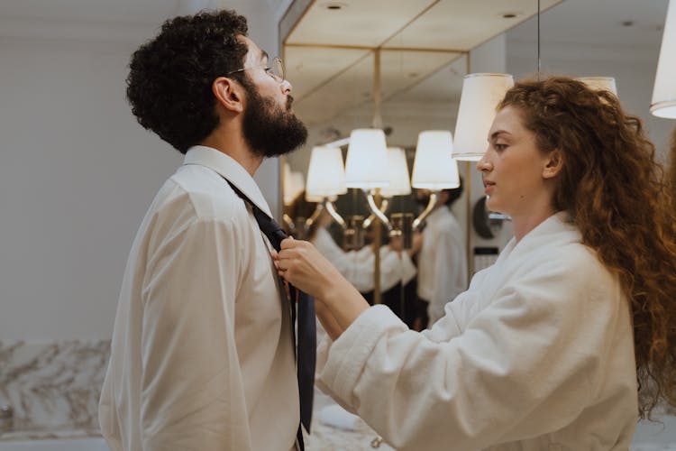 Woman Tying Necktie For A Man