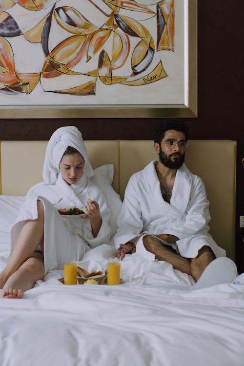 Free Couple in Bathrobes Having Breakfast in Bed Stock Photo