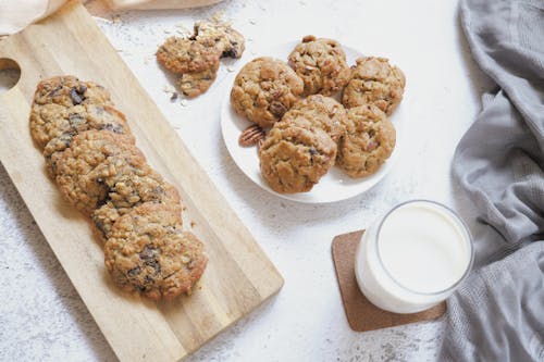 Free Cookies and Glass of Milk on White Surface Stock Photo