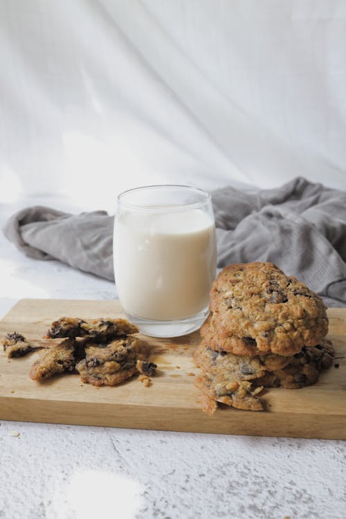 Free Cookies and Glass of Milk on a Wooden Surface Stock Photo