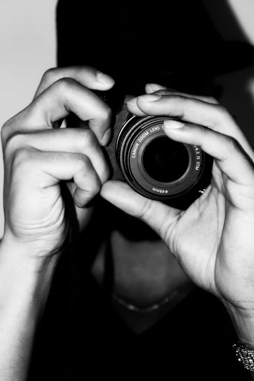 Grayscale Photo of a Person Holding Camera