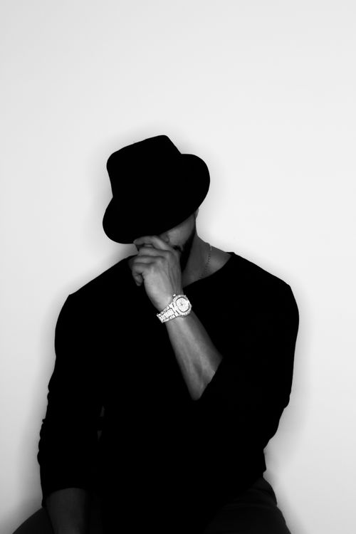 Free Monochrome portrait of a man in a fedora and watch, showcasing elegance and mystery. Stock Photo