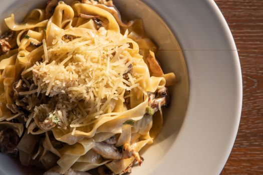 Indulge in a close-up of creamy pasta topped with Parmesan, capturing the essence of Italian cuisine.