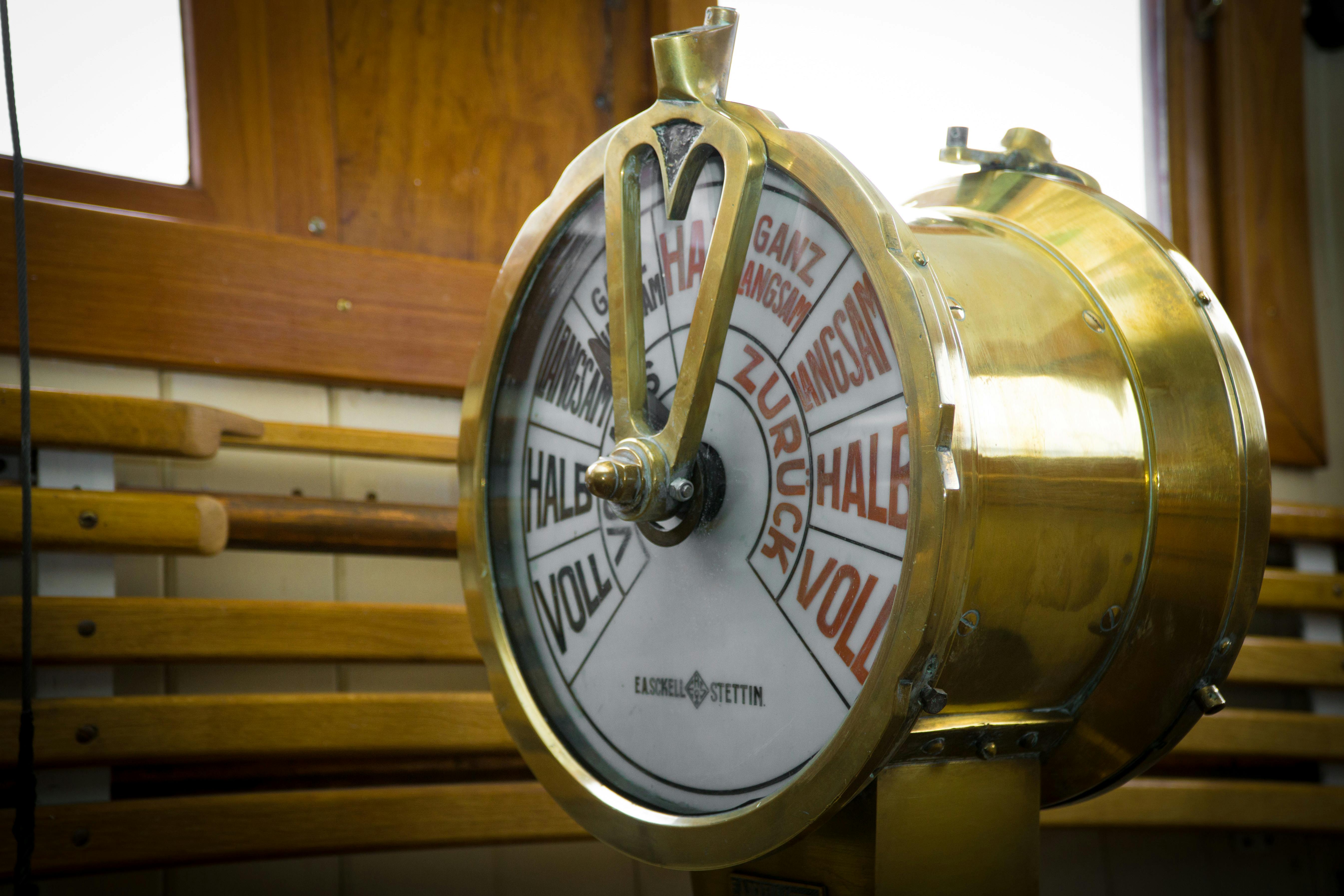 close up photography of round brass colored ship throttle device