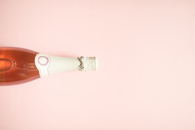 Chilled rose bottle on a soft pink surface — photo by Leeloo The First on Pexels