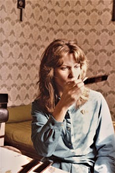 A woman examines a film strip in a vintage-styled, cozy room.
