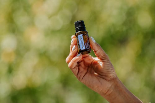 Person Holding an Essential Oil Bottle
