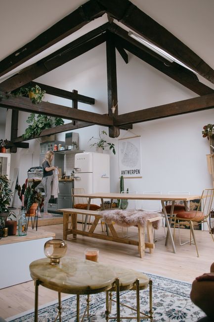 Female in kitchen with modern interior design with wooden furniture and creative ceiling