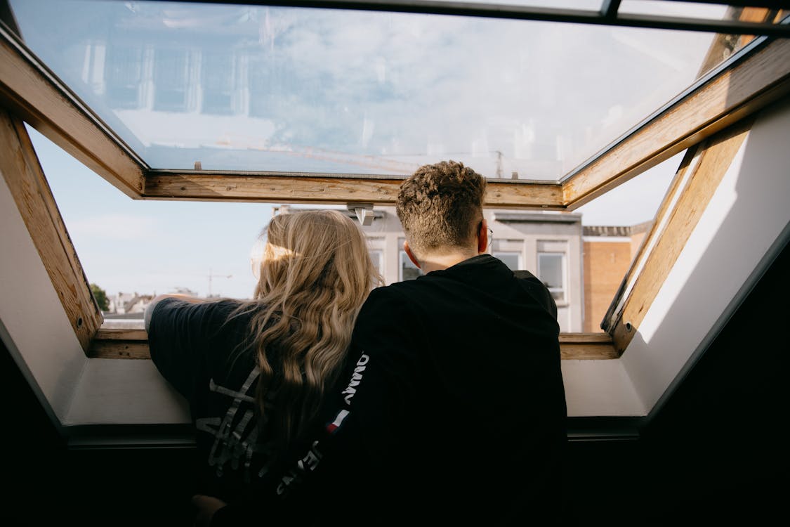 Un couple devant une fenêtre ouverte