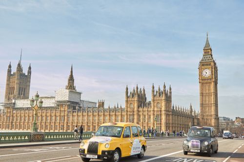 Free Iconic view of Big Ben and Palace of Westminster with classic taxis on Westminster Bridge. Stock Photo
